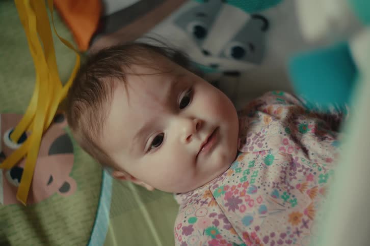 Baby lying awake playing
