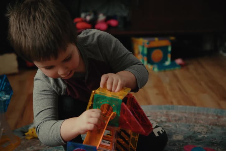Little boy in a room taking apart and playing with toys