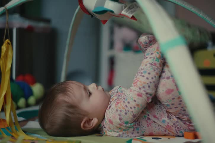 Baby in pajamas lying down playing