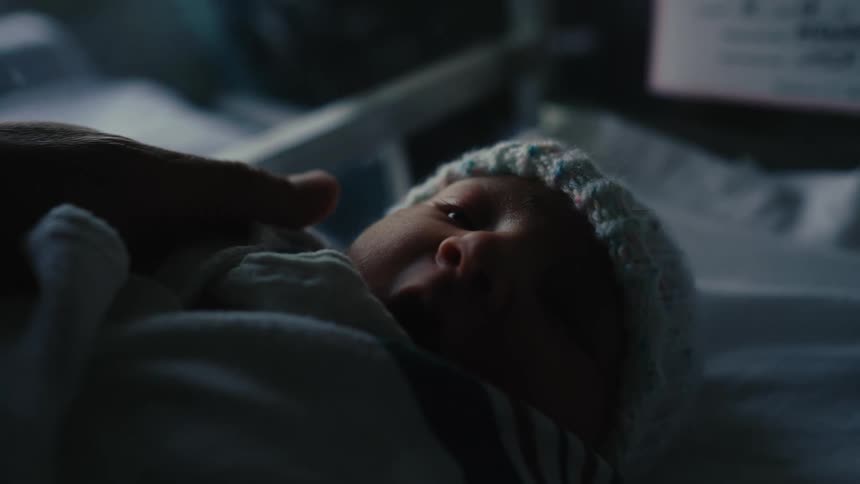 Hand caressing a newborn baby