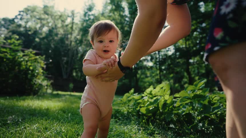 Adult helping a child walk outdoors