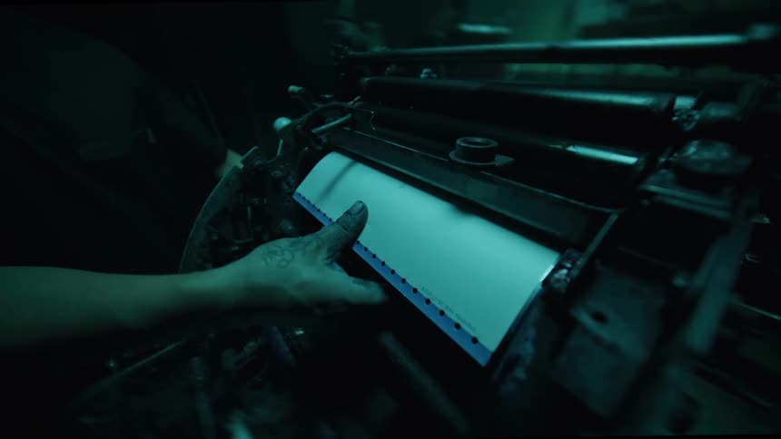 Person putting a paper into a manual machine