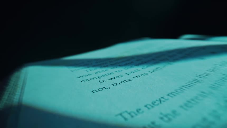 A book with its pages slightly fanned open is presented in a closeup shot emphasizing the texture of the paper and the printed text the lighting creates subtle shadows giving depth to the open book ready for reading