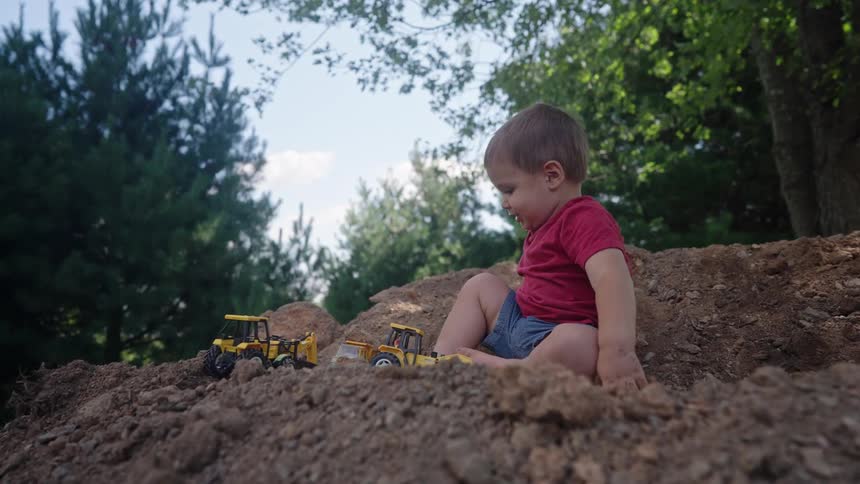 Boy on the ground playing with cars