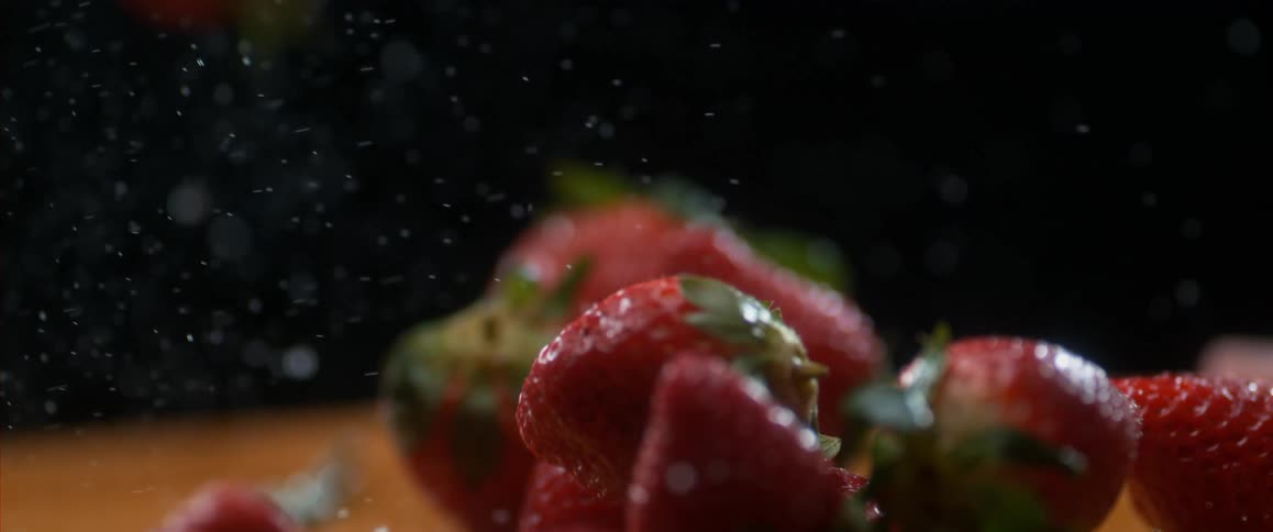 Strawberries bouncing on a table