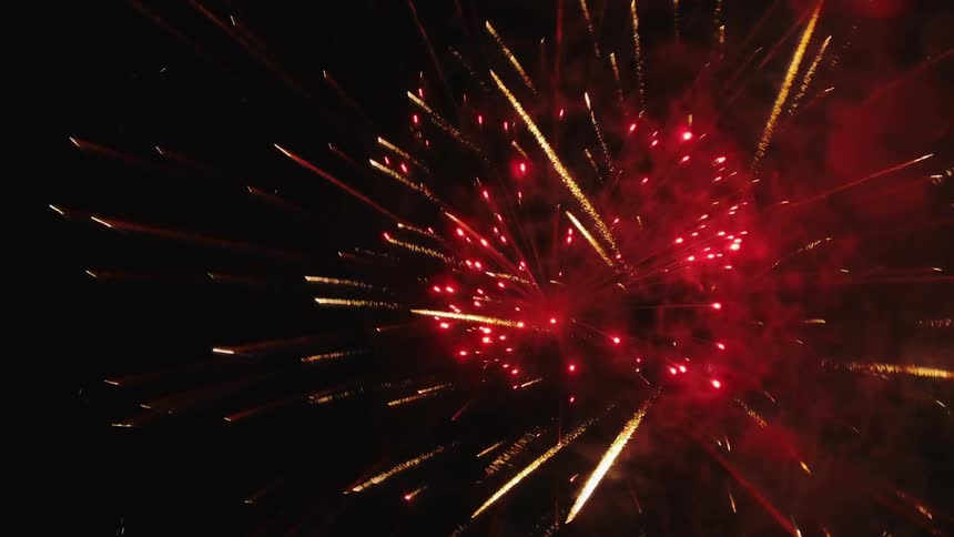 Sparks fly in the night sky exploding