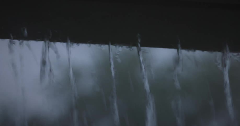 Rain falling from a gutter