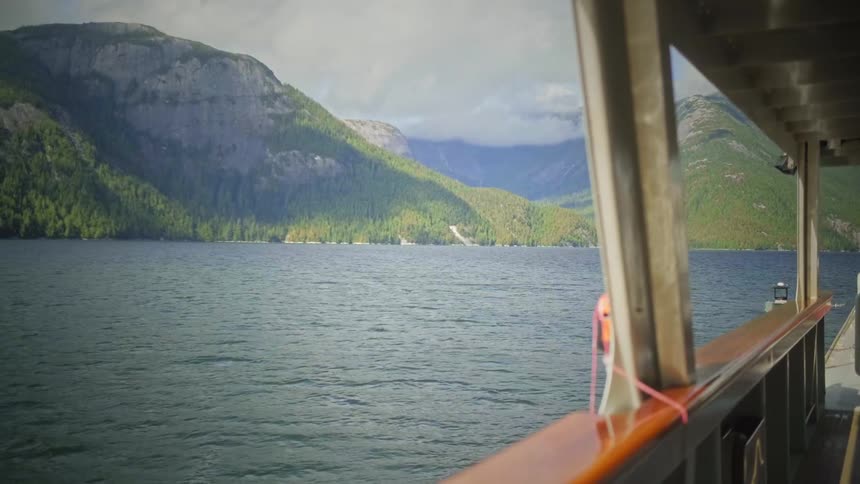 Landscape seen through a boat moving across the ocean with mountains on the horizon