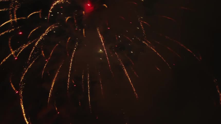 Large fireworks fill the night sky with smoke