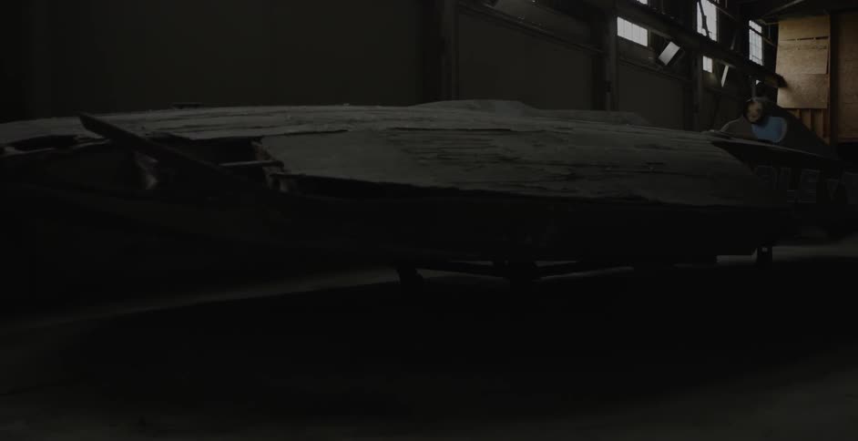 A large object sits in a dark room