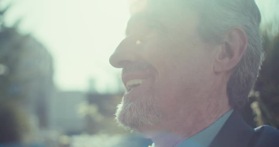 Man in suit with happy expression while standing in outdoor environment