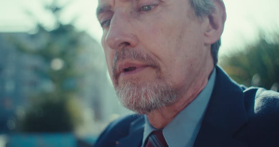 Man using smartphone with a worried expression in an outdoor setting