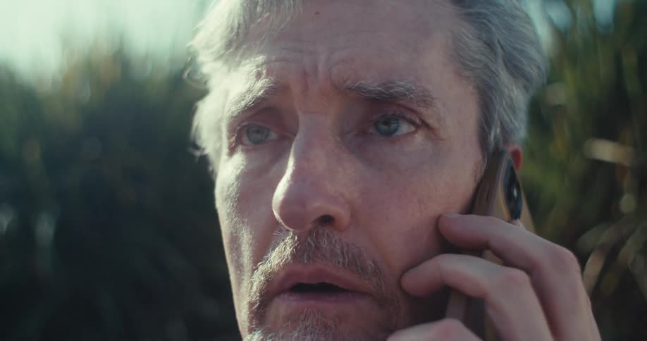 The man looks worried after answering the phone