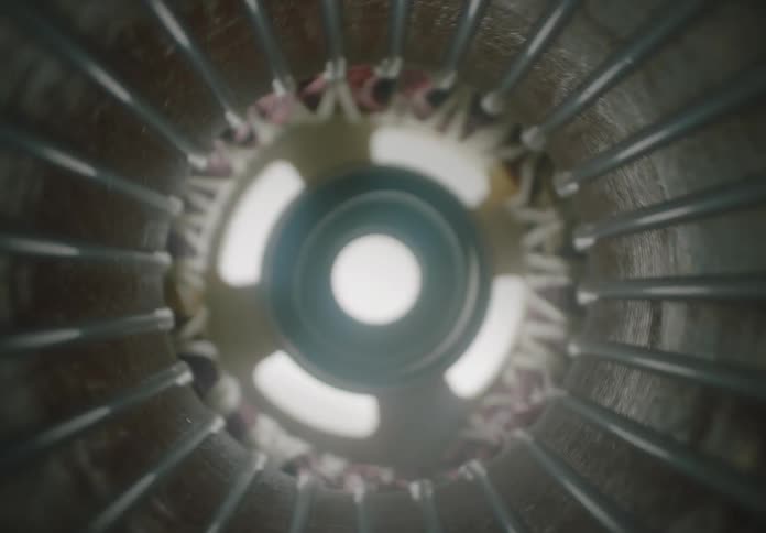 Internal view of an electric motor reveals coils and wires wrapped around a circular metal core