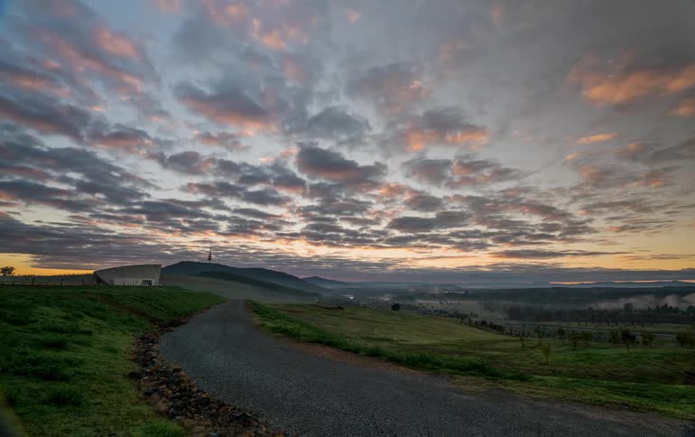 The sun is setting in the distance near this valley