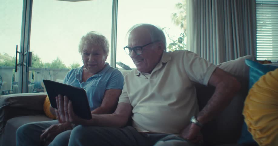 Elderly couple video calling in a cozy living room