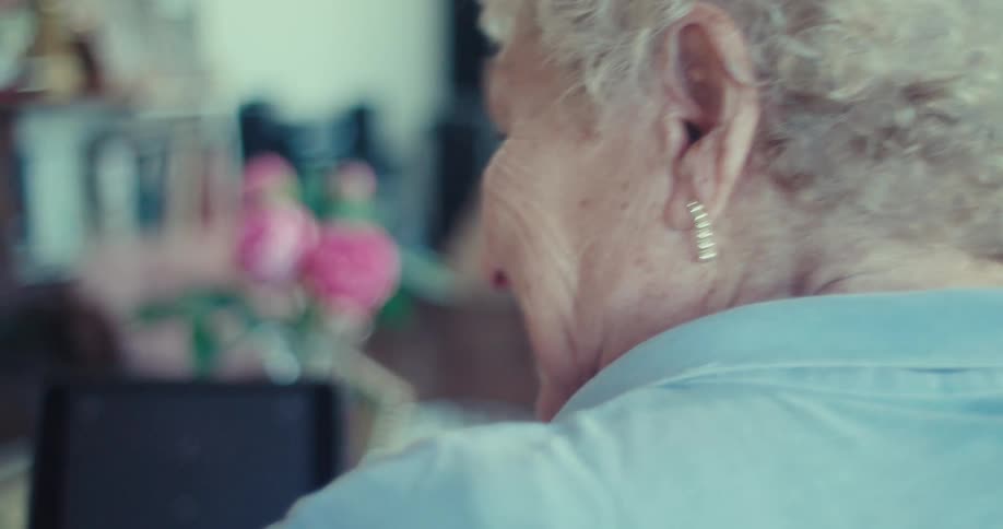 Two elderly people share a moment while using a tablet