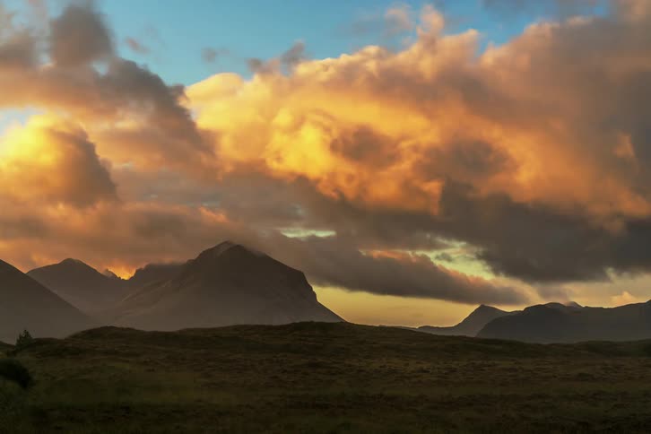 Orange clouds pass above the mountains