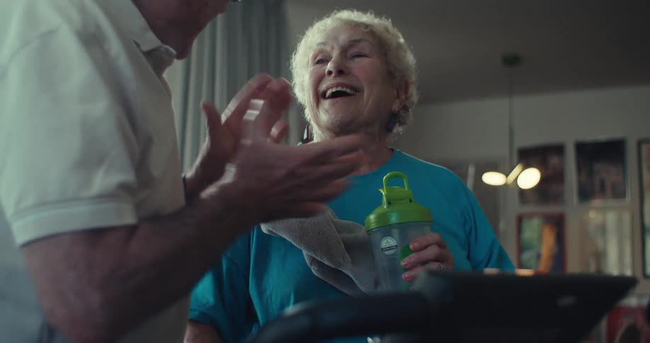Elderly couple in a living room talking happily