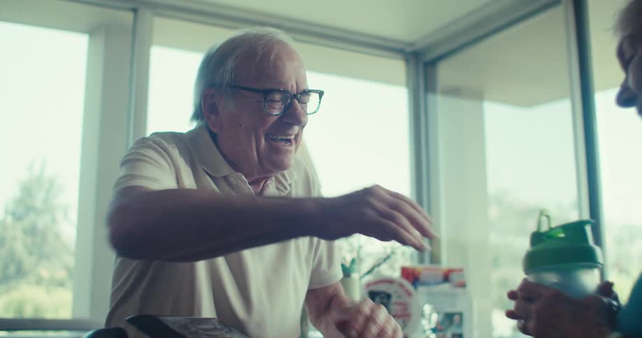 Elderly woman exercises as partner encourages her