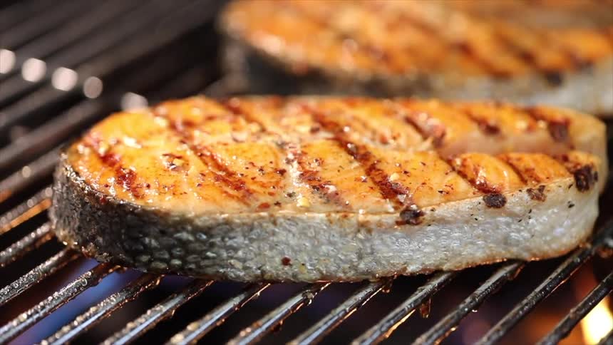 Spatula turning a slice of chicken on the barbecue grill