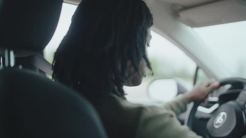 The teenager looks both ways while driving