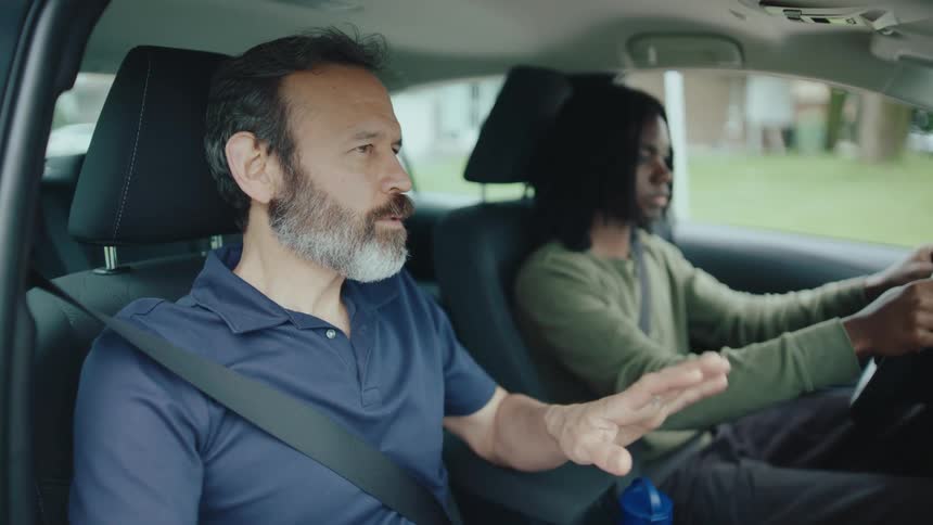Instructor teaching a man how to drive