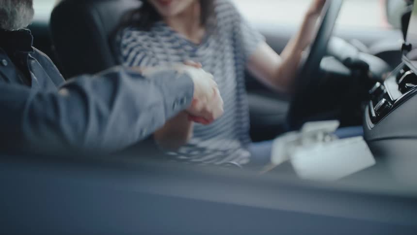 Two people greeting each other inside a vehicle