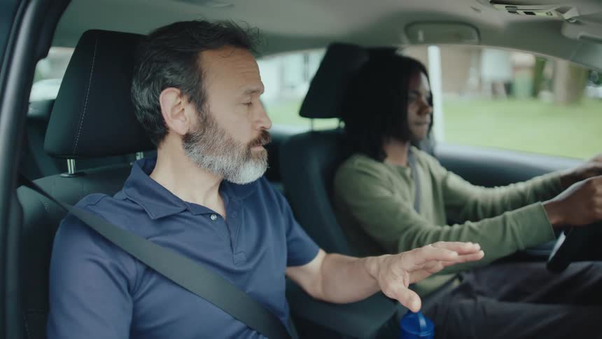 A driving instructor explaining the rules to a student while in the vehicle