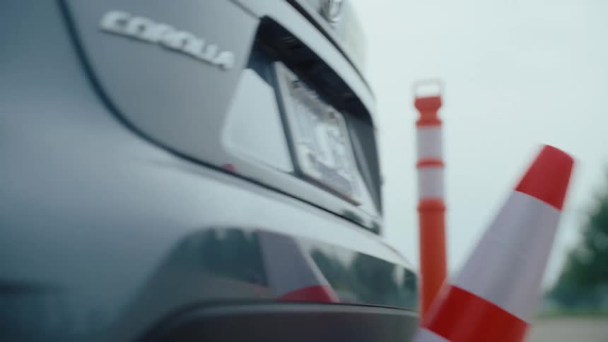 Car reversing and hitting a cone
