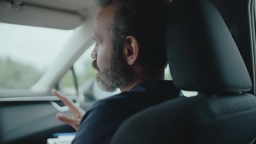 Man giving driving instructions while seated inside a car
