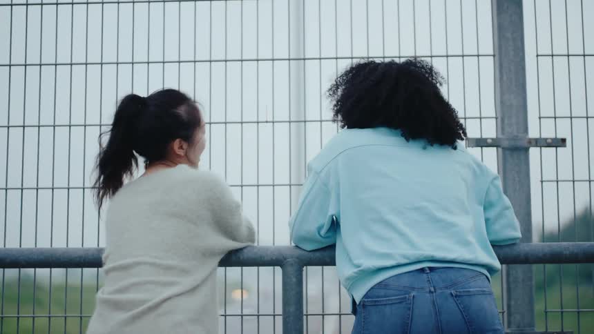 Two friends talk on the overpass
