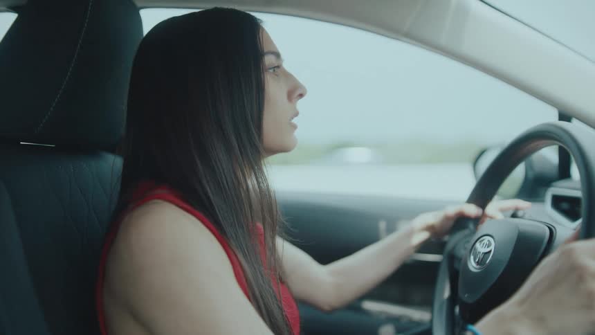 Woman driving car looking slightly worried
