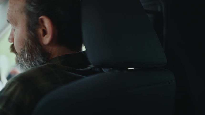 Bearded man sitting in a car talking