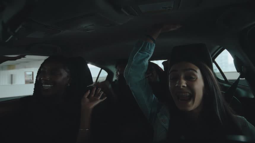 Friends are laughing and having fun while riding in a car