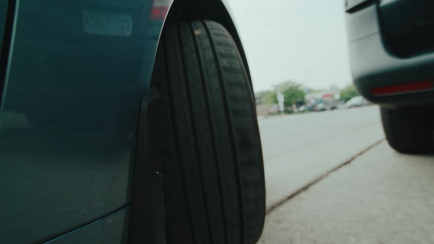 View of the wheel of a vehicle being parked on a sidewalk