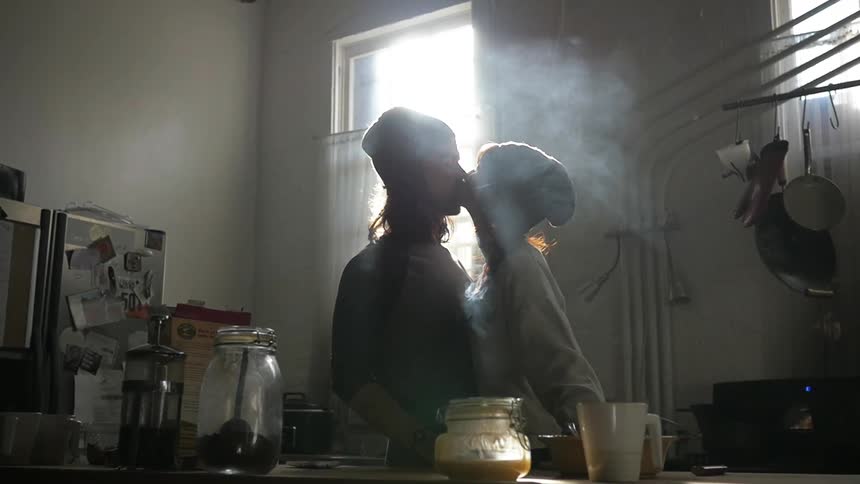 A man and woman hug in the kitchen