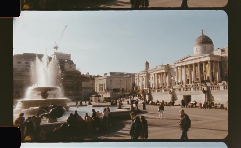 A busy european city square with a large fountain and historic architecture