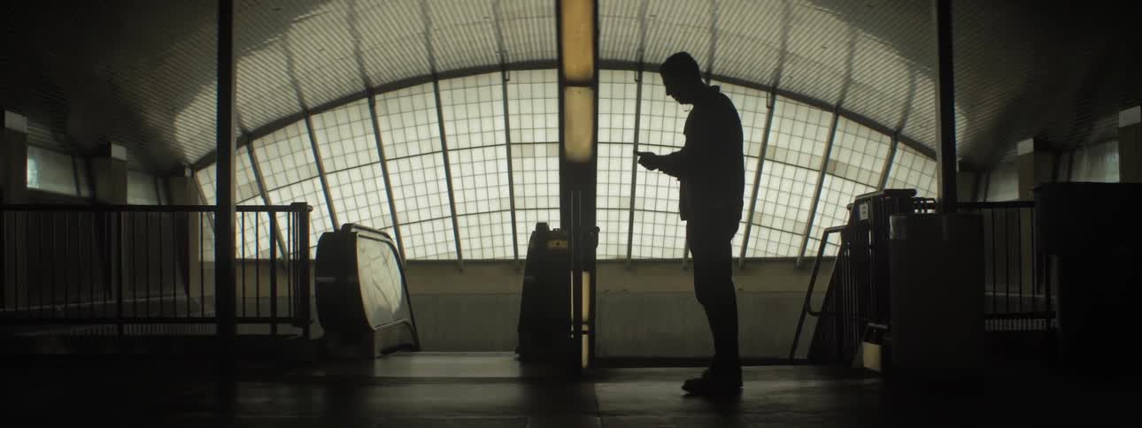 The inside of a building with a man walking around looking at something and then leaving