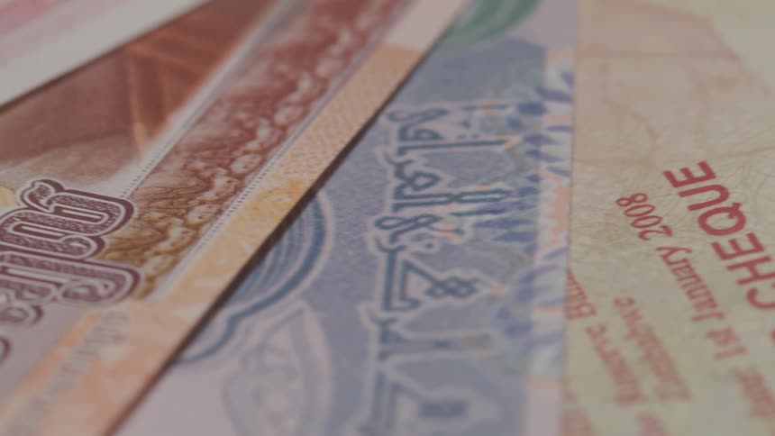 Several paper bills of foreign currency are stacked upon each other