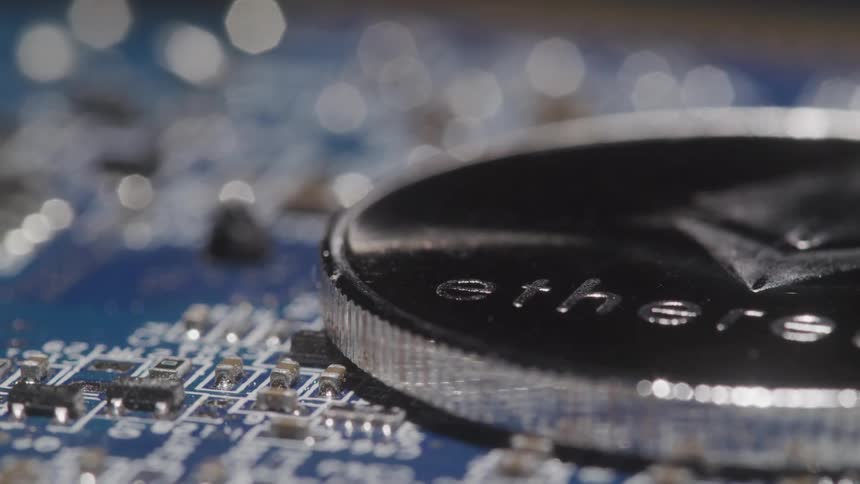A shimmering ethereum coin rests on an intricate blue computer circuit board its metallic details and the surrounding electronics catching the light