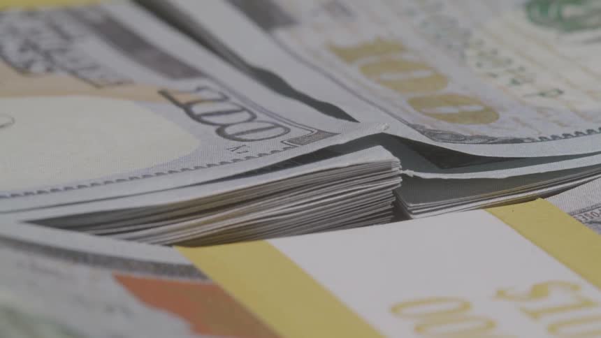 Close up of hundred dollar bills sorted into stacks of ten thousand dollars