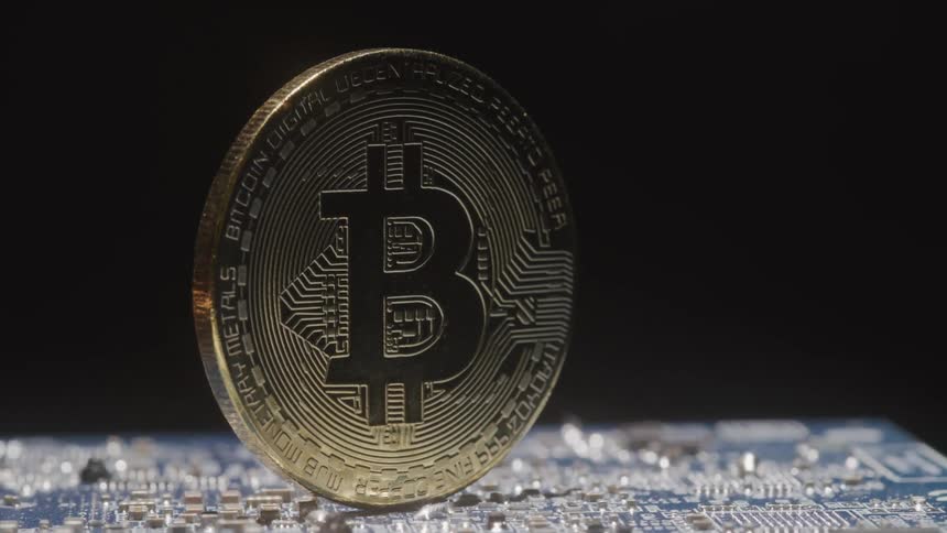 A bitcoin sitting on a computer board spin