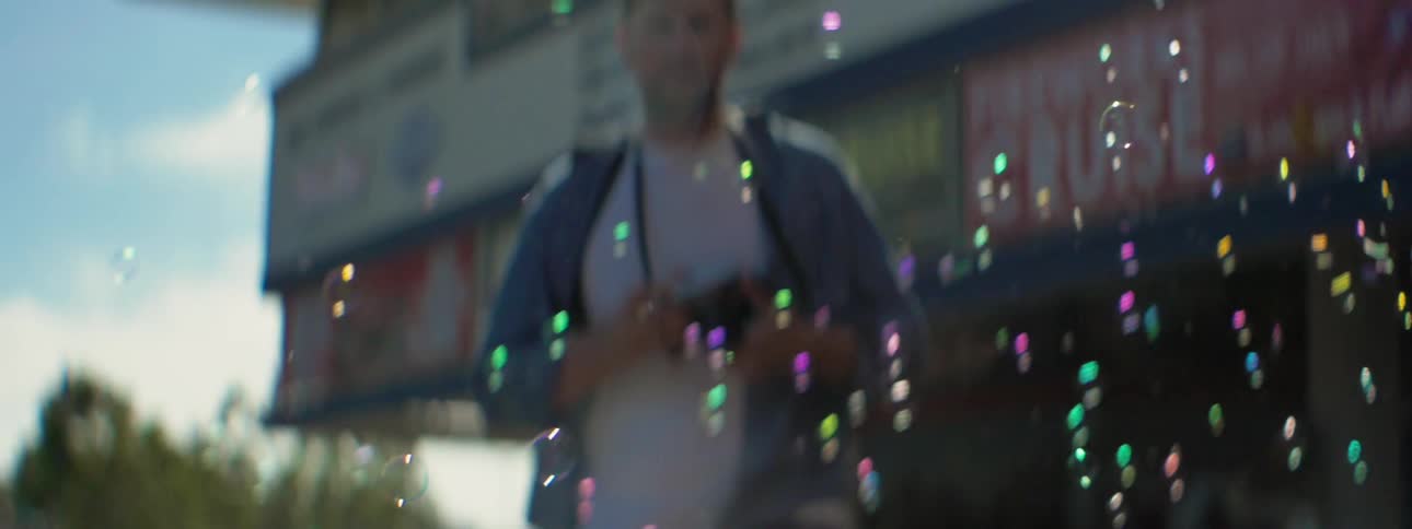 Bubbles float near a man with a camera