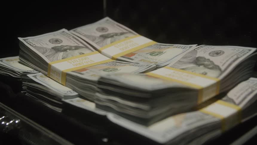 The briefcase is overfull with cash