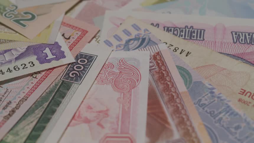 A variety of banknotes from different countries fanned out and overlapping each other the diverse colors denominations and designs of the currency are clearly visible creating a rich tapestry of global money
