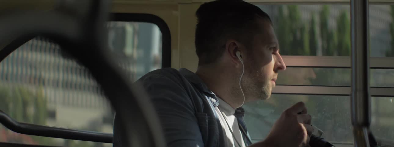 A man holds a camera on a bus