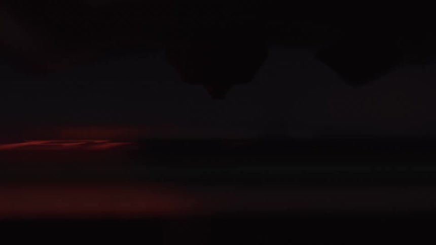 An airplane slowly sinks in the night sky while lightning flashes