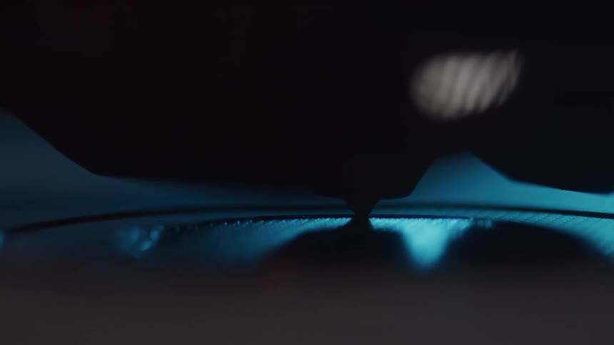 The head of a 3d printer moves back and forth as it prints onto a surface