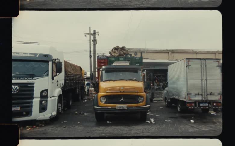 A wide shot of parked freight trucks in front of a warehouse in an industrial area